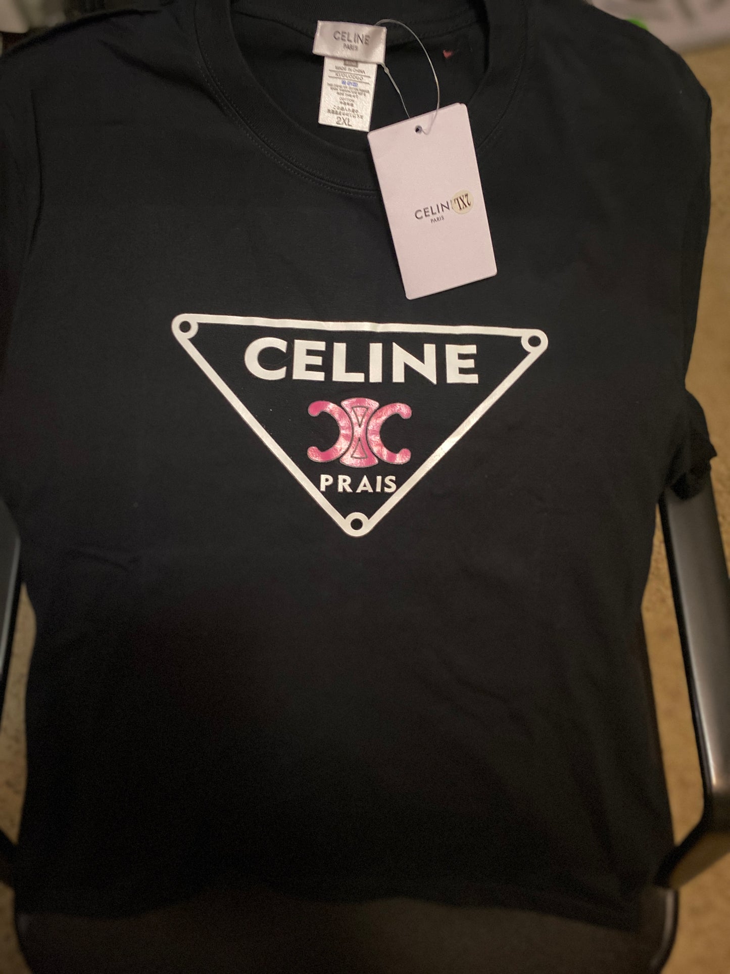 Black t-shirt with Celine logo and tag on a chair