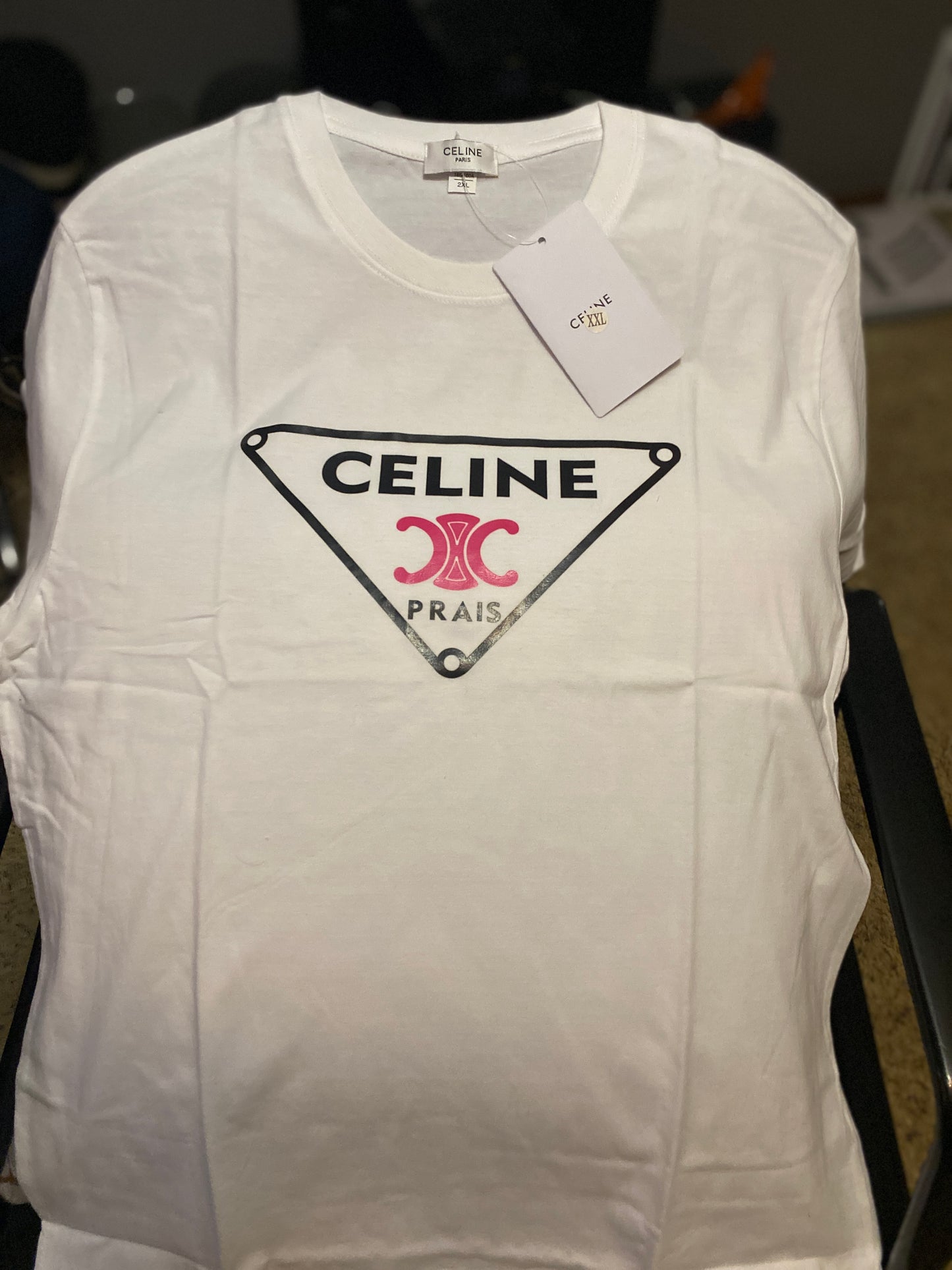 White vest with Celine logo and tag on a dark background